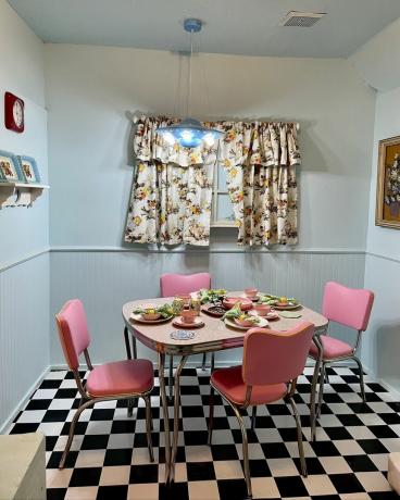 1950-luvun keittiö vaaleanpunaisilla tuoleilla ja shakkilaudalla