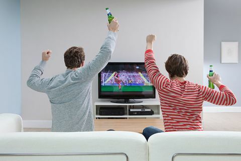 Kaksi miestä katsomassa jalkapalloa televisiosta