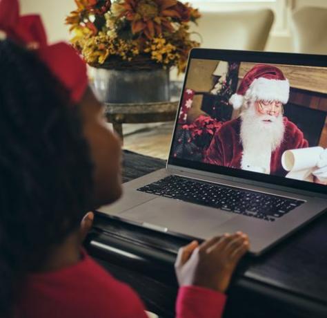 pieni tyttö, puhuu joulupukille tietokoneen videoneuvottelupuhelussa