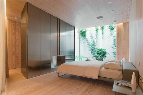Moderni makuuhuone, jossa parivuode ja lattiasta kattoon ulottuvat ikkunat