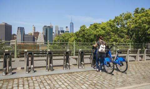 Nainen ottaa polkupyörän Manhattanin taivaanrannan edessä New Yorkissa