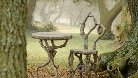 kuva faux bois -tuolista ja pöydästä, joka on asetettu puiden keskelle sumuisena päivänä