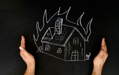 Kotivakuutuskonsepti Mies suojaa taloa käsin tulesta
