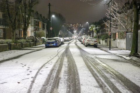 Pohjois-Lontoossa lumen peittämä tie ...