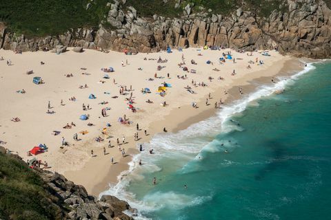 Vierailijat nauttia auringosta Porthcurno Beach lähellä Penzance 28. kesäkuuta 2018.